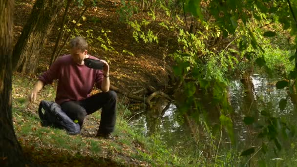 Opgewonden Man in 360vr bril kijken Video 360 graden voelt echt draaien zijn hoofd virtuele spelen in zonnige herfst dag Park in Lake zit naar beneden — Stockvideo