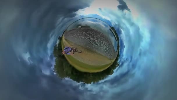 Little Tiny Planet 360 Degree Man Filming Riding a Bicycle Along River Sea Stony Bank Backpacker is Traveling Warm Autumn Day Cloudy Sky Tour to Opole — Stock Video