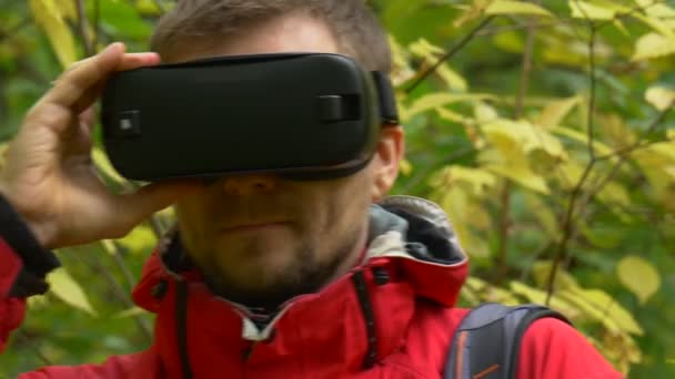 Homme avec des lunettes de réalité virtuelle pour une promenade. dans les bois — Video