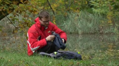 Adam alır vr kulaklık koyar ve vr gözlük dönüm onun baş arıyor etrafında sanal oyunlar su bulutlu gün parkta izlerken Video 360 derece