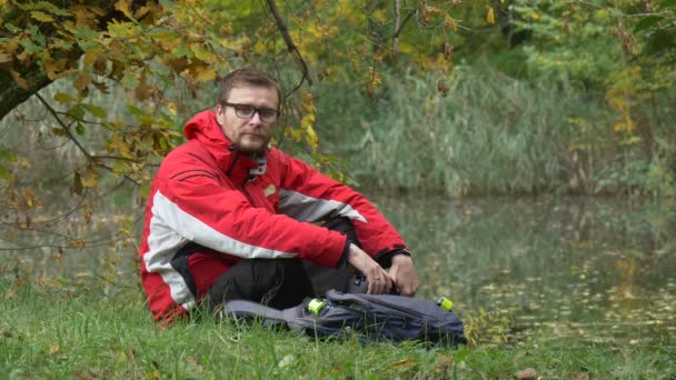 L'uomo mette su auricolare vr fa clic sul telefono Guarda il video 360 gradi in vr occhiali Giocare giochi virtuali Rimuove l'auricolare Guardando l'acqua nel parco nuvoloso — Video Stock