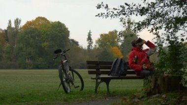 Vr kulaklık tezgah izlerken Video 360 derece oynarken sanal oyunlar oturan bulutlu sonbahar gün Backpacker Park parkta bankta oturan adam