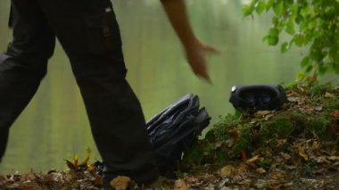Adam alır 360vr gözlük tıklama Smartphone yere bulutlu sonbahar gün Park su Smartphone sırt çantası kullanarak oyun oynarken Video izlerken geliyor