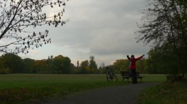 Adam yola ahşap Bank sonbahar manzara Bisiklet tezgah arkasında bakarak doğa, dinlenme aşağı uzanan Park Bench, ayakta