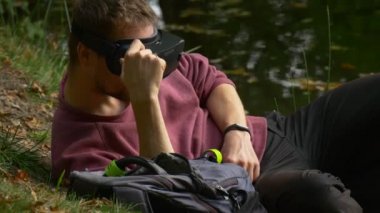 Video 360 derece izlerken zemin güneşli günde sanal oyunlar oynamaya baş dönme yalan 360vr gözlüklü adam gözlük nehir Gölü Parkı alır