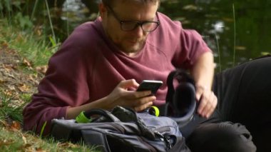 Biri 360vr gözlük tıklamayla telefon izlerken Video 360 derece oynarken sanal oyunlar yalan yere güneşli gün turist üzerinde Resting nehir göl