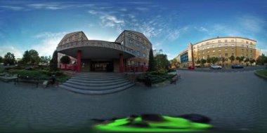 360vr Video Timelapse adam yürüyüş etrafında üniversite üniversite Binası öğrenci bekleyen için sınıflar Meydanı Yeşil çimenler bulutlu gün genç adam sarı olduğunu