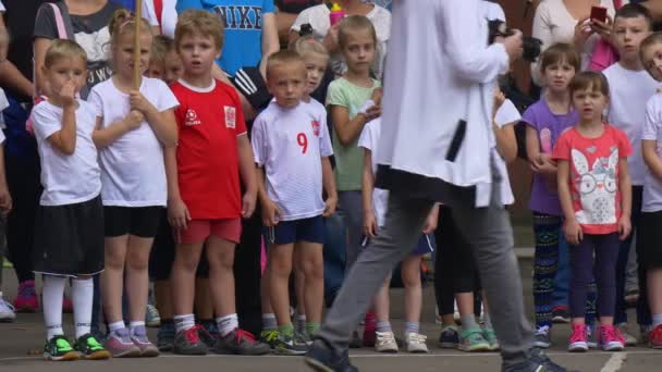 En stor grupp av skolbarn ser på en pojke — Stockvideo