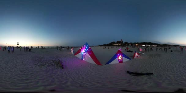 360vr Video driehoek-vormige verlichte vliegers kleurrijke lampen speelgoed worden geplaatst op het zandstrand van zee zonsondergang mensen lopen door zand Festival Leba vliegers — Stockvideo