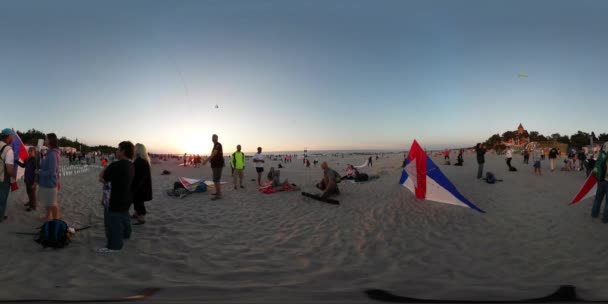 晴れた日の海の砂浜で過ごす凧祭りウエバ ポーランド人夕日子供たち両親に三角形の凧を飛ばすつもりで 360 vr サンレミバスティオン ビデオ人 — ストック動画