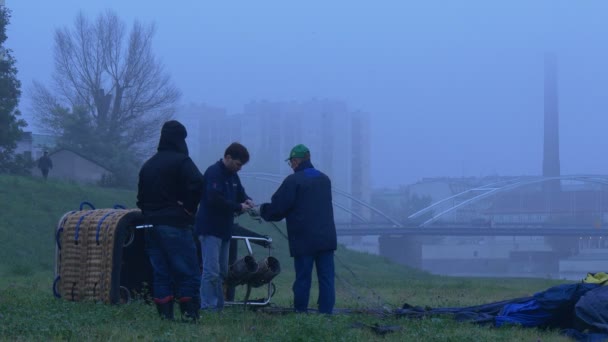 Trzech mężczyzn przygotowują się do rozpoczęcia balon. na brzegu rzeki Odry. — Wideo stockowe