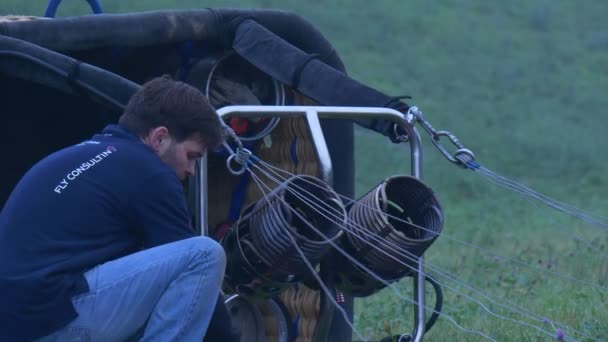 Человек готовит корзину воздушного шара к полету — стоковое видео