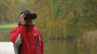 360vr adam göl Video 360 derece izlerken Bankası'nda sanal oyunlar sonbahar yeşil bulutlu gün parkta gözlük ve Reed sarı ağaçlar Kuru