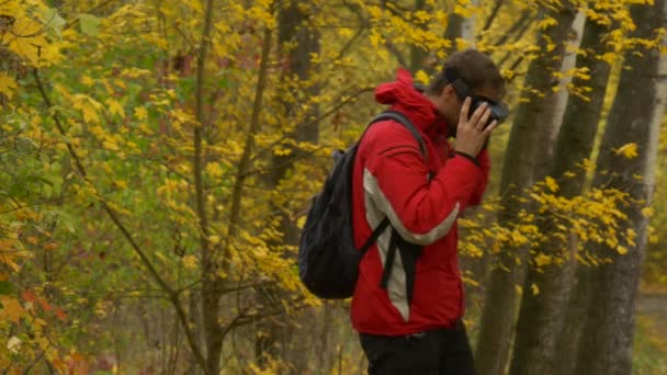 Hombre con gafas de 360Vr caminando y viendo videos 360 grados jugando juegos quita los auriculares mirando al mochilero del paisaje de otoño con gafas graduadas — Vídeo de stock