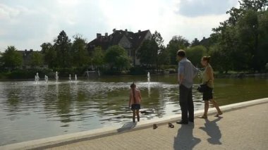 Küçük kız ayak bileği-derin su üzerinde duruyor