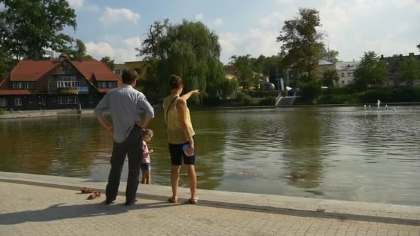 A pequena família está no banco do lago — Vídeo de Stock