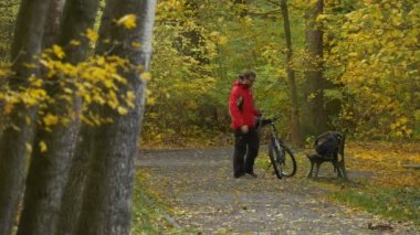 Comes yerde bir bisiklet oturur tezgah sonbahar gün Park sokak Backpacker için be dinlenme arasında altın ağaçlarda sonbahar zemin kaplı sarı yaprak