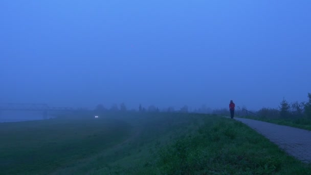 Sabah yaklaşırken yol boyunca yürüyen bir adam. Yalnızlık — Stok video