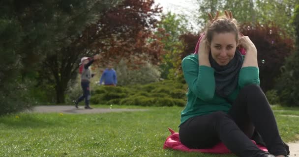 草の上に座って女の子と幸せママ. — ストック動画
