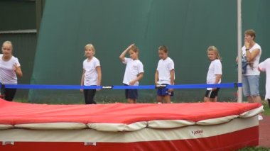 Küçük kız gerçekleştirmek atletik egzersiz yüksek atlama