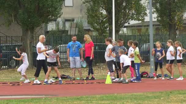 Młodych trenerów stoi na trawie w pobliżu tor wyścigowy — Wideo stockowe