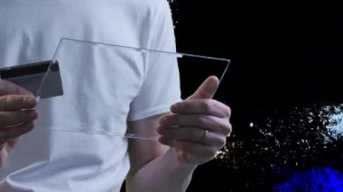 Adam bir kredi kartı yazarak numarası sanal Tablet satın aracılığıyla Internet çalışma Forex Döviz sohbet üzerinde Skype genç adam beyaz T-Shirt üzerinde tutuyor 