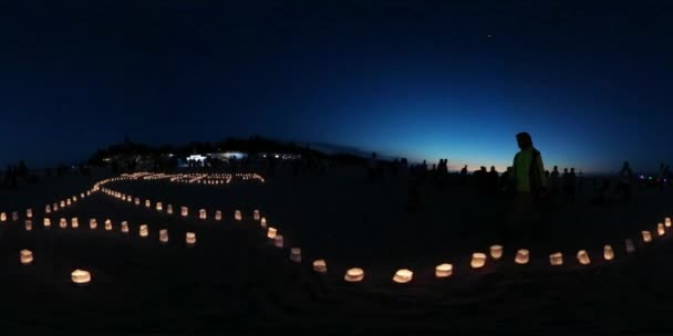 Vidéo 360Vr L'homme filme la parole Leba sur la plage faite de bougies brûlantes sur une côte en soirée Personnes au festival de cerfs-volants Leba Pologne Familles ensemble — Video