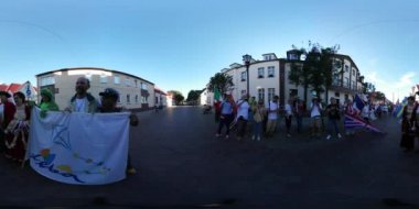 Uçurtma Festivali Leba katılımcılar Town adlı güneşli bir günde dinlenme şehir meydanında Ulusal kostümleri 360vr Video çokuluslu kalabalığa akşam günbatımı