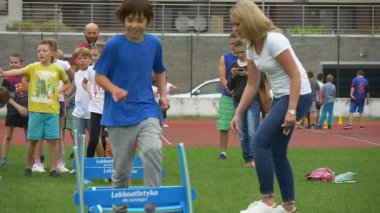 Opole, Poland - Sep 17 2016: Little Boys and Girls Jump Through Low Obstacles During Run. Each of Them Successfully Reaches a Finishing Line. Together Children Take Part in a Children's Sports