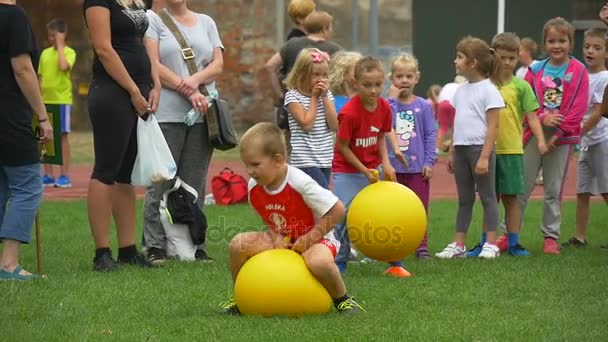 Küçük çocuklar sarı lastik top palan — Stok video