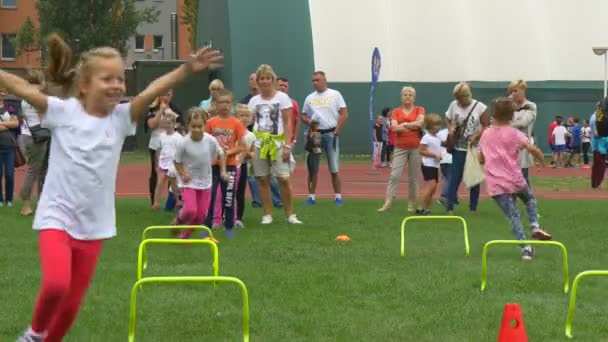 Niñas y niños participan en una carrera de obstáculos — Vídeos de Stock