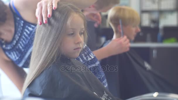 Eröffnungstag im Salon Stylisten machen Frisuren für Kunden kleines Mädchen Teenager Junge Friseure kämmen blonde Haare andere Stylistin macht einen Haarschnitt — Stockvideo