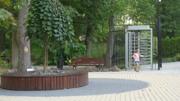 Ein kleines Mädchen spaziert allein durch den Stadtpark — Stockvideo