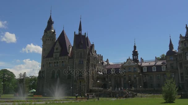 Συντριβάνι άτομα σε Moszna κάστρο αυλή εκλεκτικό στυλ κτίριο πάρκο χλοοτάπητες Blue Sky μπαρόκ στυλ παλάτι ΝΕΟ-γοτθικό ΝΕΟ-αναγεννησιακού στυλ των φτερών — Αρχείο Βίντεο