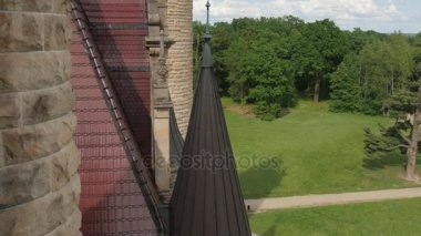 Tuğla duvarlar ve kuleleri Moszna Castle Park çimenler yeşil ağaçlar güneşli bir gün mavi gökyüzü eklektik barok saray Neo-Gotik Neo-Rönesans stilleri kanat tarz