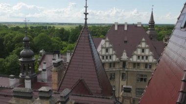 Bulutlu gökyüzü Eclectic Palace kale Neo-Gotik Neo-Rönesans tarzı bir ufuk güneşli günde binalar çan kulesi Moszna Castle Park çimenler yeşil ağaçlar