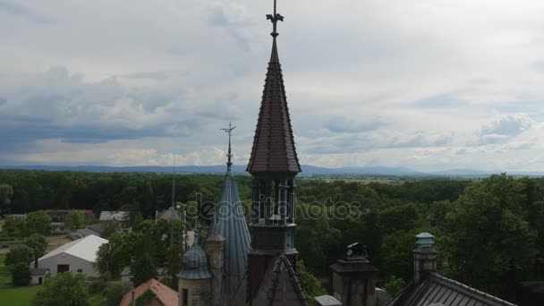 Moszna épületek Bell Tower kastélypark körül zöld fák napos nap felhős ég madarak repülni fölött a tornyok táj eklektikus stílusú palota vár — Stock videók