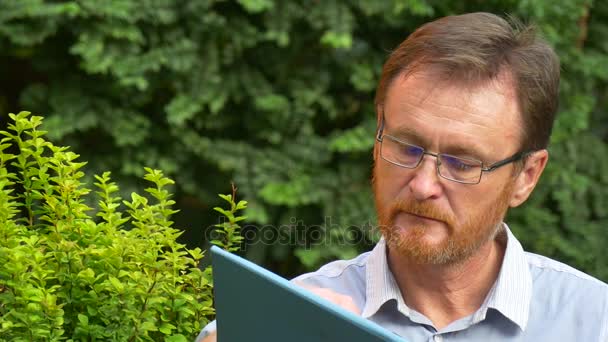 El hombre terminando la lectura de un último párrafo — Vídeos de Stock