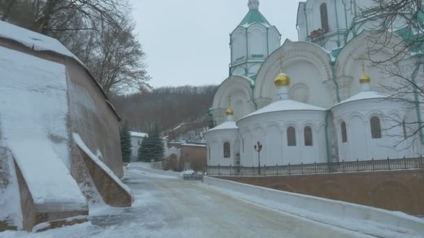 Панорама здания Свято-Горного Лавры Пещерный монастырь в зимних обнаженных ветвях Деревья Пейзаж Облачный снежный день Православные религиозные здания — стоковое видео