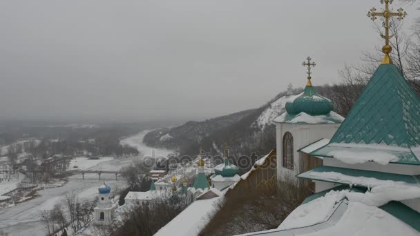 Vista da observação Deck Montanhas Sagradas Lavra Paisagem Rio Caverna Mosteiro no inverno Abeto Árvores Paisagem Nublado Dia nevado Ortodoxo Edifícios Religiosos — Vídeo de Stock