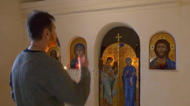 Christmas Icons Svyatogorsk adam dua ediyor yakınındaki Ortodoks Kilisesi turizm Holding yanan mum tebeşir mağara mümin turist Lavra tarafından yürüyor