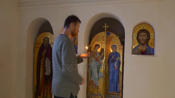 Vánoce v Svyatogorsk člověk sám protíná ikony náboženské obrazy kostela kaple uvnitř cestovního ruchu křída jeskyně náboženské obrazy křížů zlacené dekorace — Stock video