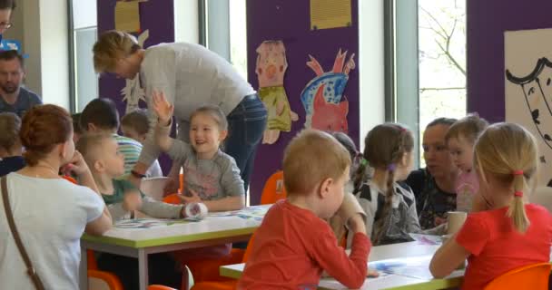 Barnens dag Opole barn föräldrar i klassrummet gör papper leksaker personer som sysslar med konst i klassrummet glada människor familjer sitter vid skrivbord — Stockvideo