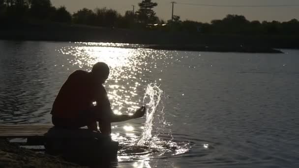 Man Sits on a Brink of a Small Wooden Pier — Stock Video