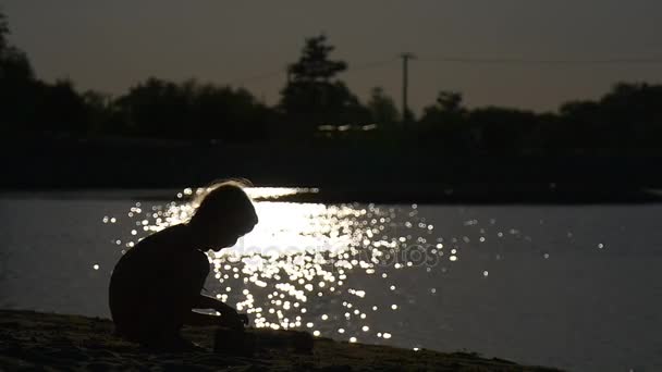 Fille creuse un petit pôle dans un sable — Video