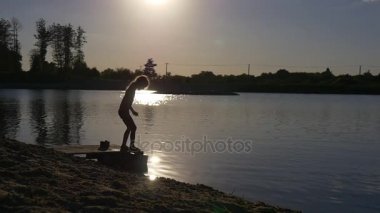 Küçük kız bir iskelede oturur