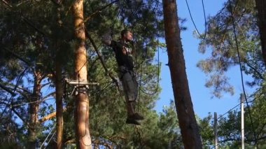 Summer Fun For Adults Outdoors. Rope Road Between the Trees. the Man With the Insurance Goes Through the Ropes Between the Trees.