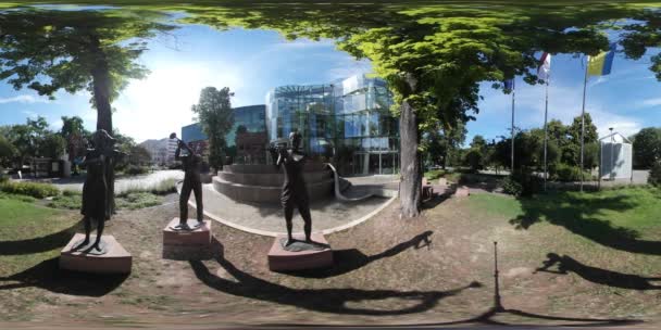 360vr Video stadsplein dag Opole standbeelden drie mensen lopen in de buurt van moderne Building in Park groene bomen zonnige dag Oekraïens en Poolse vlaggen zijn zwaaien — Stockvideo
