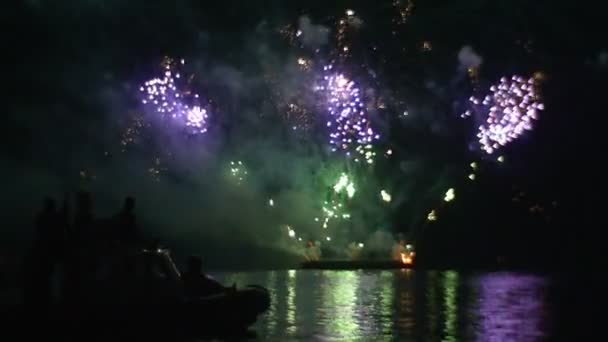 Menschen im Boot beobachten das farbige Feuerwerk große Pyrotechnik zeigen Licht Rauch Ereignis in großer Weise Feier in einem großen romantischen Abend — Stockvideo