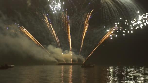 烟花在水面上亮色的火花，反映在水表面和消失在黑暗的天空在规模盛大的庆祝活动 — 图库视频影像